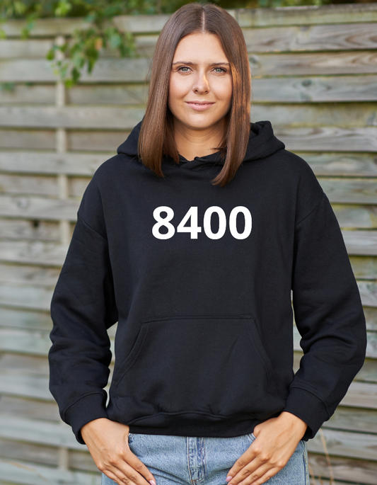 Zwarte hoodie met de witte opdruk ‘8400’, het postcode-nummer van Oostende, gedragen als casual streetwear.