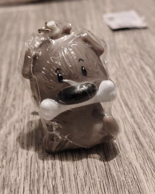 Sleutelhanger in de vorm van een hond met een bot in zijn bek
