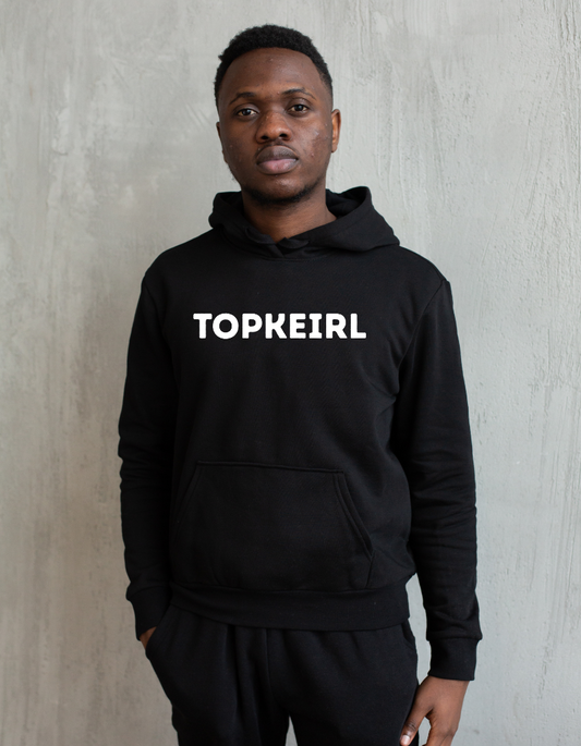 Zwarte hoodie met de West-Vlaamse tekst ‘Topkeirl’ in witte letters, gedragen als casual streetwear.