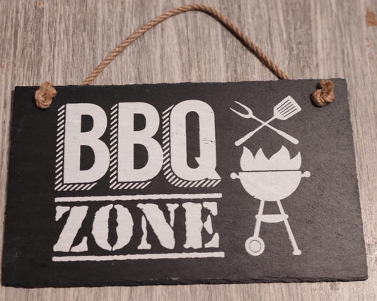 Zwart leisteen bordje met witte tekst BBQ Zone en barbecue-illustratie