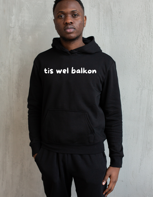 Zwarte hoodie met de West-Vlaamse tekst ‘Balkon’ in witte letters, gedragen als casual streetwear.