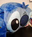 Zachte blauwe pluche knuffel in kussenvorm met grote zwarte ogen en uitstekende oren.