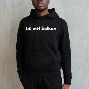 Zwarte hoodie met de West-Vlaamse tekst ‘Balkon’ in witte letters, gedragen als casual streetwear.
